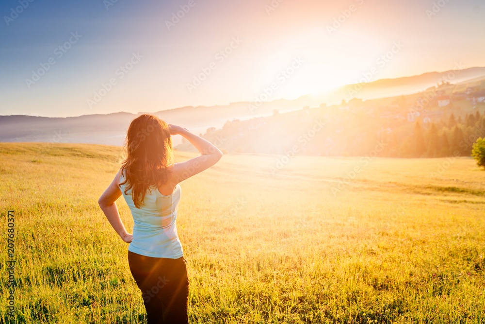 Happy girl at summer meadow enjoying beauty morning in mountains Happy girl at summer meadow enjoying beauty morning in mountains