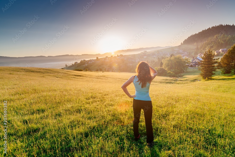 Happy girl at summer meadow enjoying beauty morning in mountains Happy girl at summer meadow enjoying beauty morning in mountains