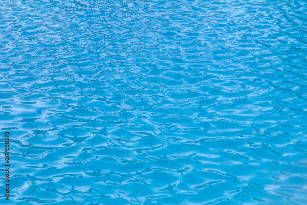 small waves and ripples on the blue water of the swimming pool