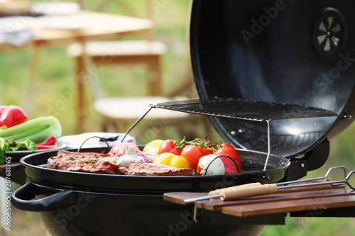 Barbecue grill with meat and vegetables outdoors, closeup