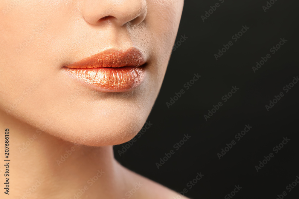 Obraz premium Beautiful young model with creative lips makeup on black background