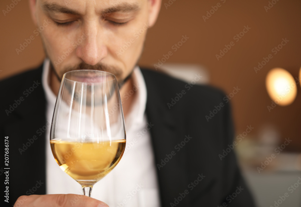 Young man with glass of wine indoors