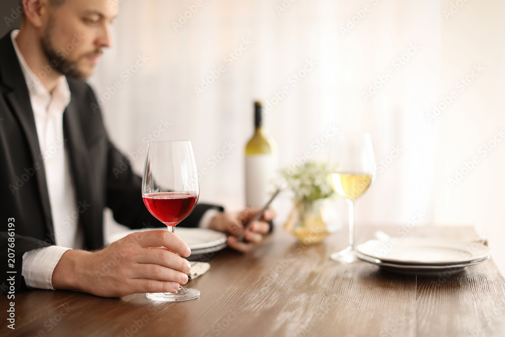 Man with glass of wine at table in restaurant Man with glass of wine at table in restaurant