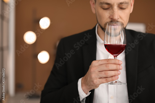 Fotografi Young man with glass of wine indoors