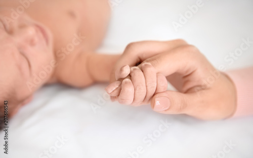 Mother holding little baby hand