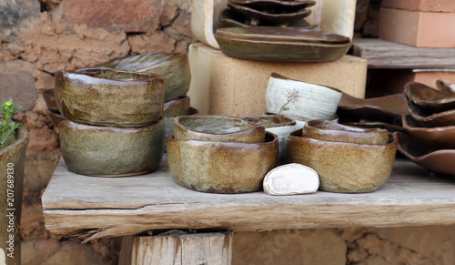 Photography Traditional pottery on wooden shelves.
