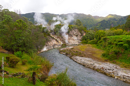 Fumaroles along a waterway created by springs in central part of Furnas village on Sao Miguel Island, Azores, Portugal. Lush flora in area of the easternmost active trachytic volcano on the island.