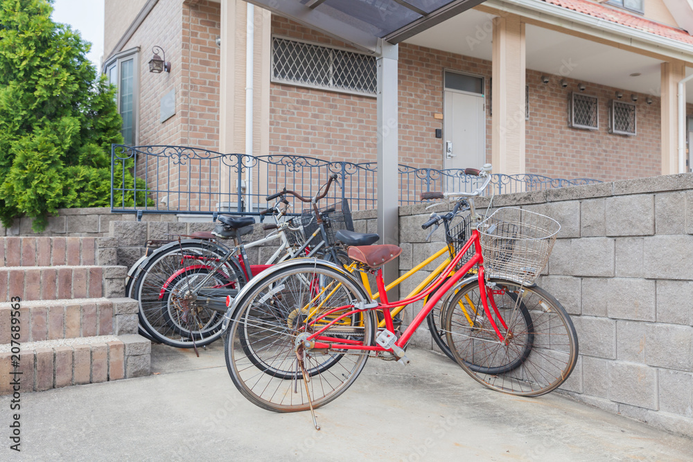Many bicycle parked at bicycle parking space in front of home residential
