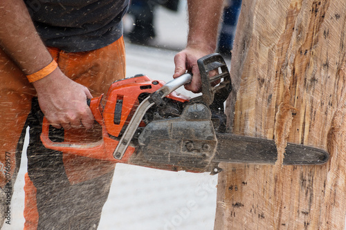 man with a chain saw is working on a tree trunk