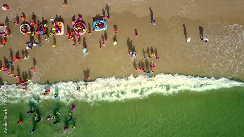 foamy waves roll on beach children gambol