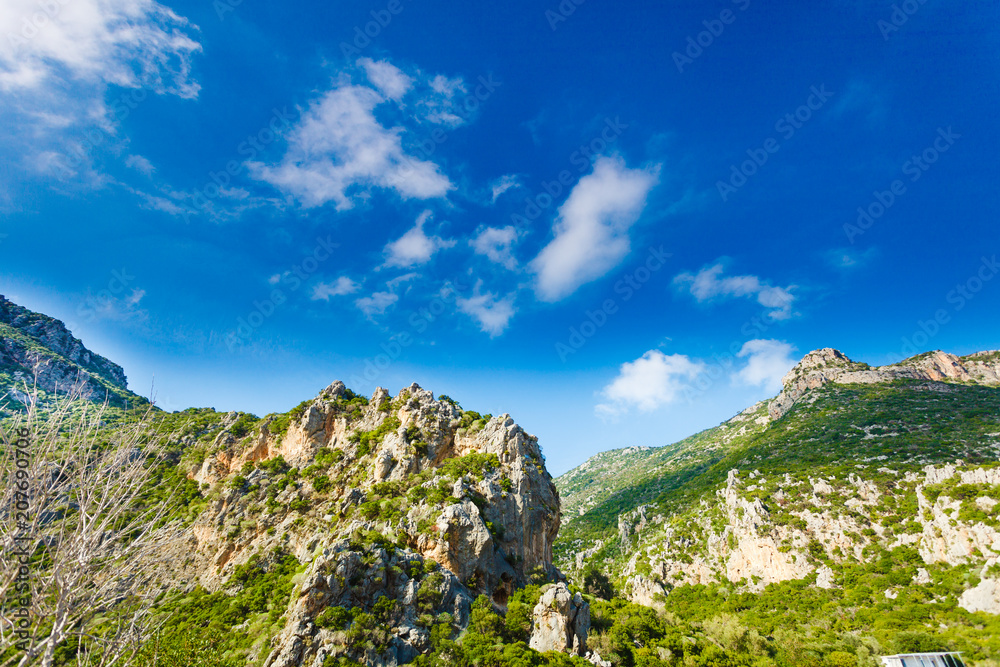 Mountain cliffs against sky with clouds