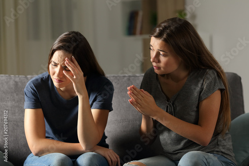 Friend begging forgive in the night at home photo