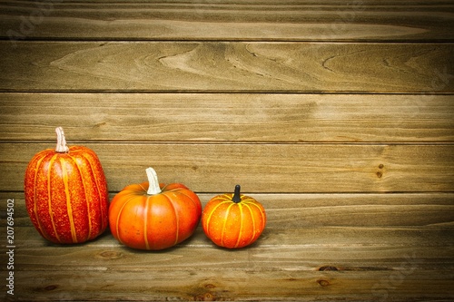 Pumpkins with a wood background providing copy space.