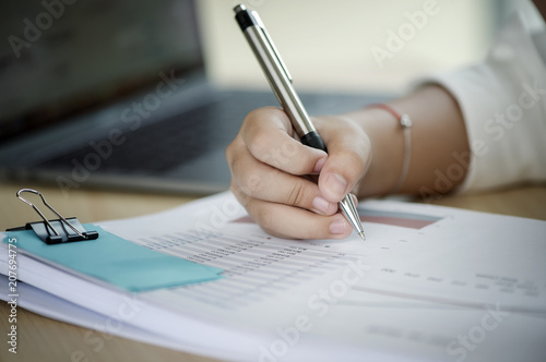 Close up hand of businesswoman writing on paper