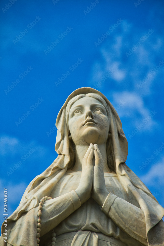 A statute of the Virgin Mary looking up while praying.