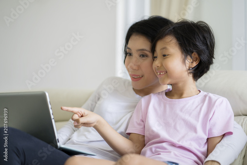 Little girl watching a movie with her mother