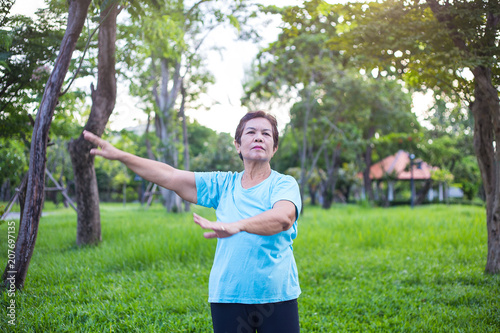 Senior Asian woman have happiness and have wellbeing life by exercise with freshness in the park, maintaining the health of an elderly woman in retirement concept.