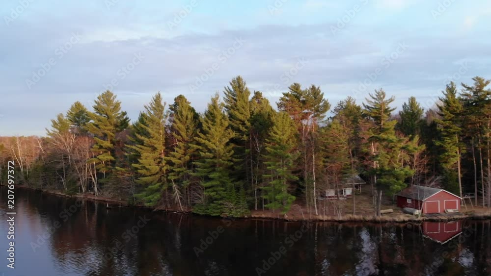 Aerial of Red Cabin On Still Water Reveal Larger Lake