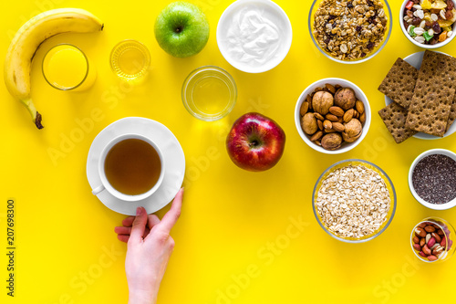 Ideas of healthy hearty breakfast for sportsmen. Fruits  oatmeal  yogurt  nuts  crispbreads  chia on yellow background top view copy space