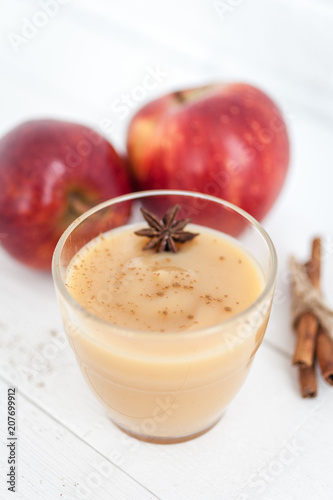 Apple sauce, puree in a glass with spices on a white wooden table 