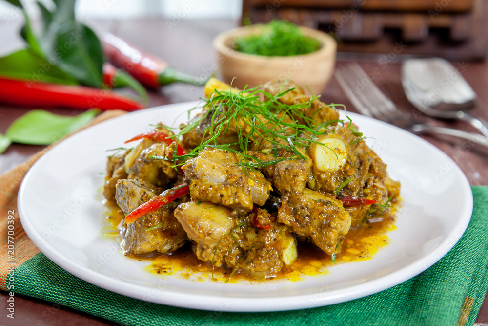 Fried pork bones spicy with yellow curry paste on dish thai style food