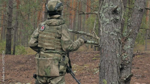 Soldiers in camouflage with combat weapons make their way outside the forest, with the aim of capturing it, the military concept photo