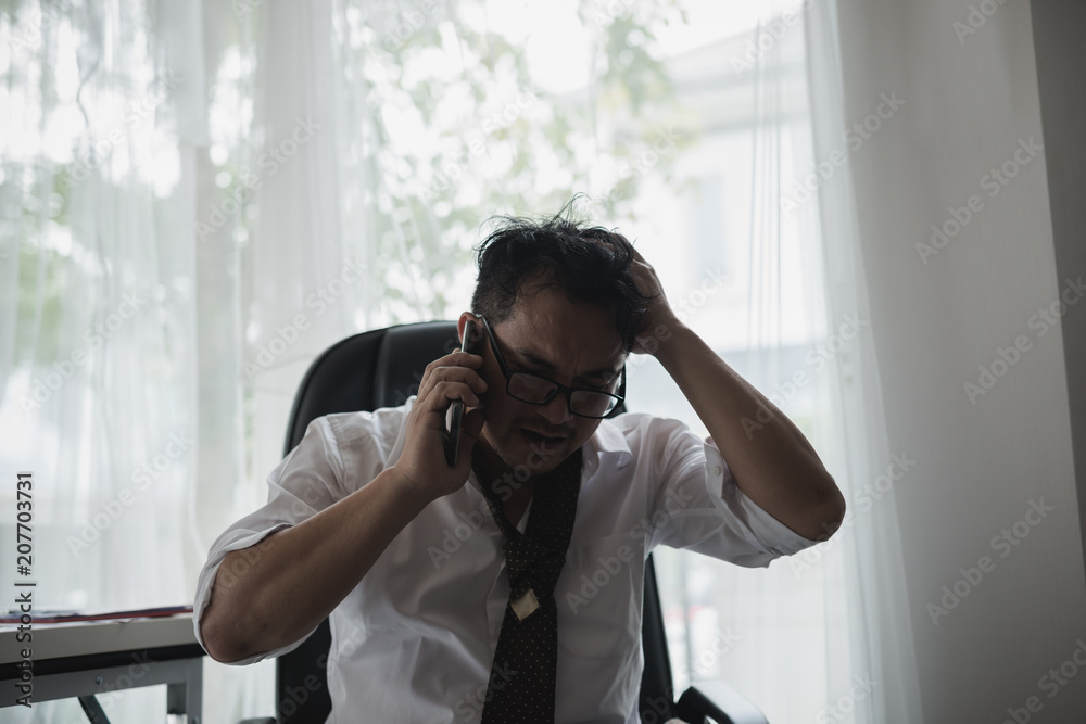 Businessman upset stressed, talk on the telephone at office desk surrounded by paperwork. feel worry ,headache ,disappoint during working. Businessman upset stressed, talk on the telephone at office desk surrounded by paperwork. feel worry ,headache ,disappoint during working.