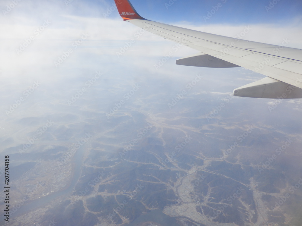 Obraz premium 飛行機の翼と地上