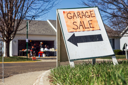 Garage sale sign on the lawn of a suburban home