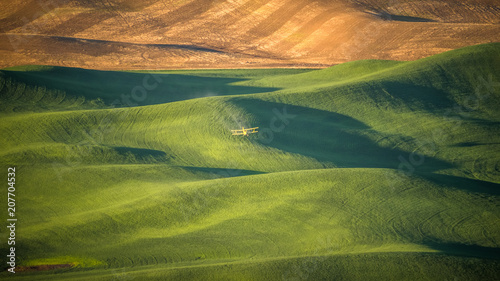 Crop Duster dropping pesticide on a wheat field in The Palouse at sunrise photo