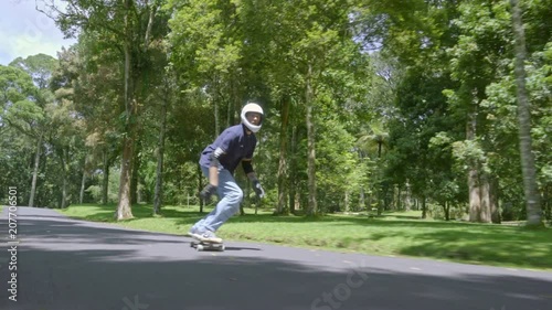 Wallpaper Mural Front view follow shot of man in helmet enjoying skateboarding in green park on warm summer day Torontodigital.ca