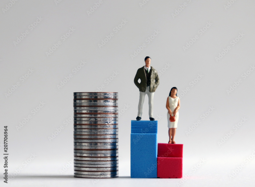 A miniature man standing on a tall blue stair beside a pile of coins and a miniature woman standing on a low red stair. A miniature man standing on a tall blue stair beside a pile of coins and a miniature woman standing on a low red stair.