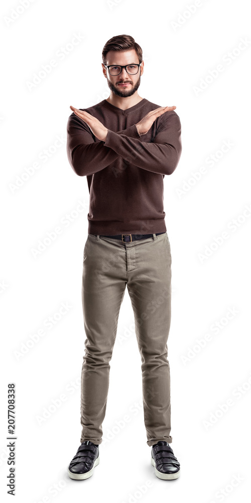 A bearded man in fashionable casual clothes stands with hands making a cross in front of him. A bearded man in fashionable casual clothes stands with hands making a cross in front of him.