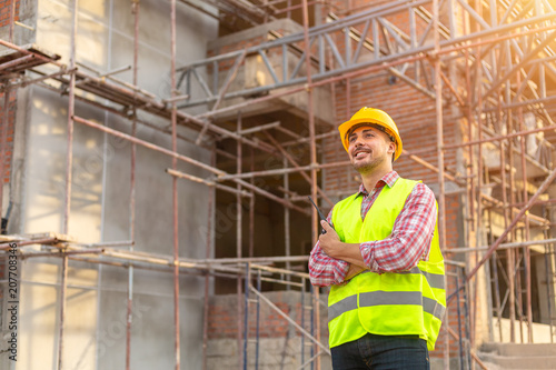 Manager Engineering in standard safety uniform working in a pouring concrete pump on construction site photo