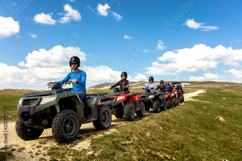 Friends driving off-road with quad bike or ATV and UTV vehicles