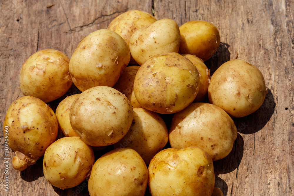 New potatoes on rustic wooden table New potatoes on rustic wooden table