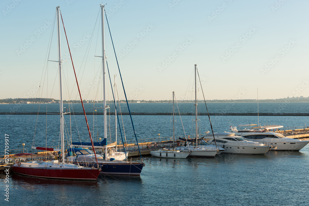 pleasure yachts moored in the harbor at the pier, six pleasure boats, early morning, concept summer and travel