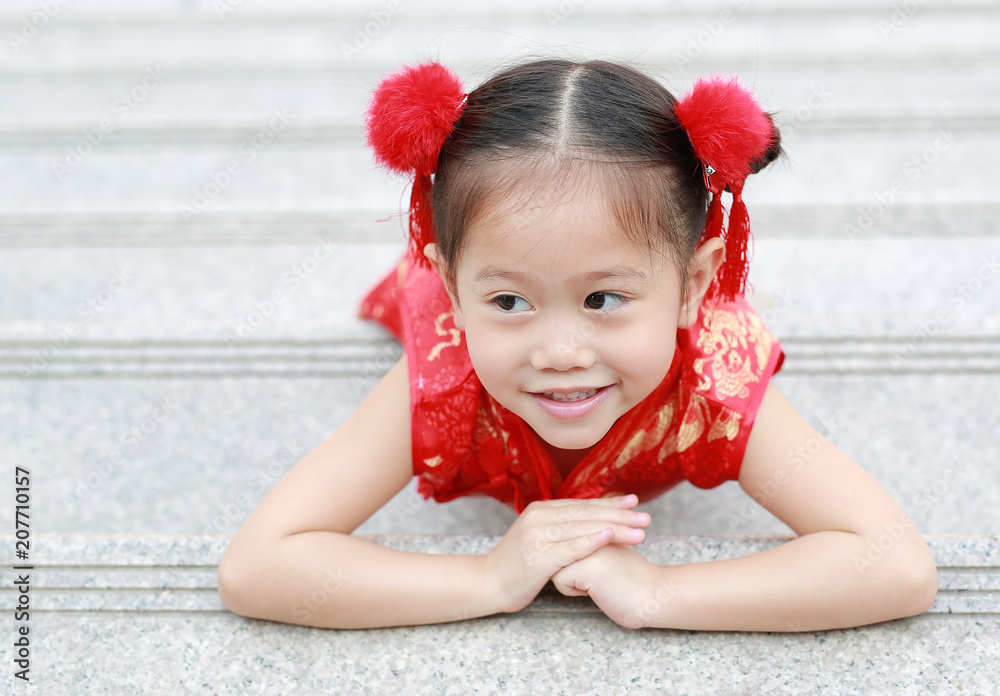 Happy little Asian child girl wearing red cheongsam with greeting gesture celebration for Chinese New Year. Happy little Asian child girl wearing red cheongsam with greeting gesture celebration for Chinese New Year.