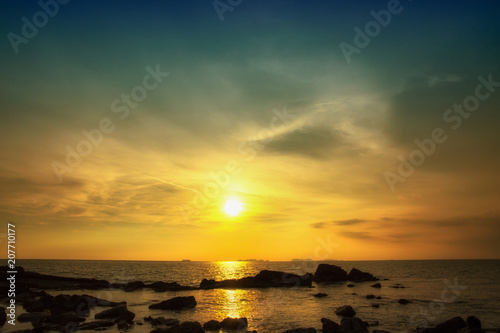 Sunset seascape with rocky beach.