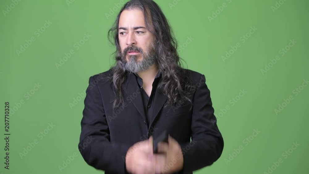Studio shot of mature handsome bearded multi-ethnic businessman with long hair Studio shot of mature handsome bearded multi-ethnic businessman with long hair