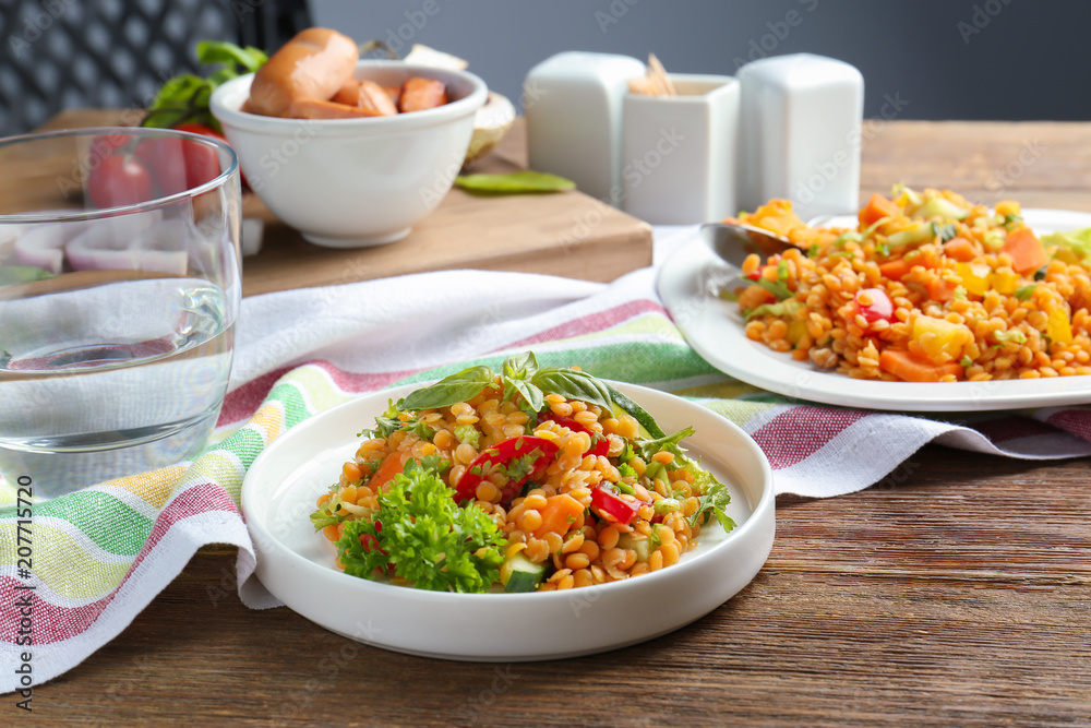 Plate with delicious lentils salad on wooden table Plate with delicious lentils salad on wooden table