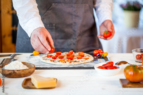 Fototapeta Naklejka Na Ścianę i Meble -  closeup hands of chef making fresh homemade traditional italian pizza. wallpaper for pizzeria and cooking food concept