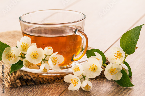 Glass cup of green tea with white jasmine flowers
