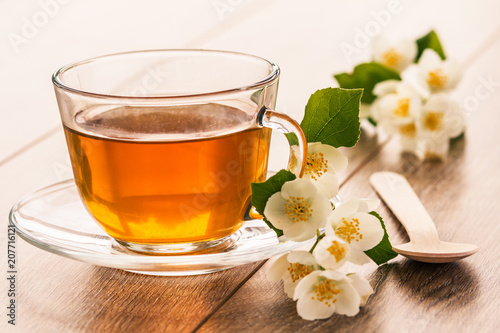 Glass cup of green tea with white jasmine flowers