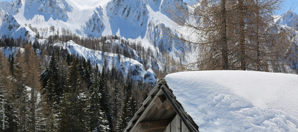 roof of a hut with snow and mountains in background