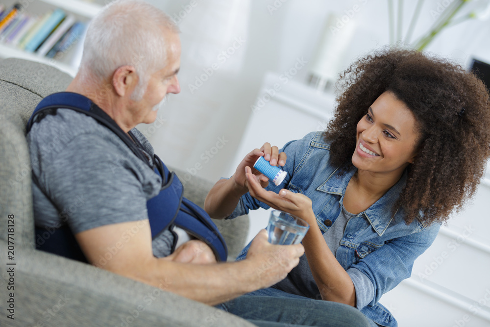 woman giving tablet to an injured man woman giving tablet to an injured man