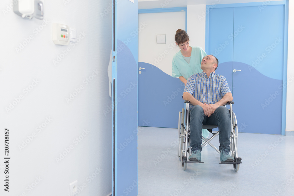 disabled man in wheelchair and nurse is pushing him disabled man in wheelchair and nurse is pushing him