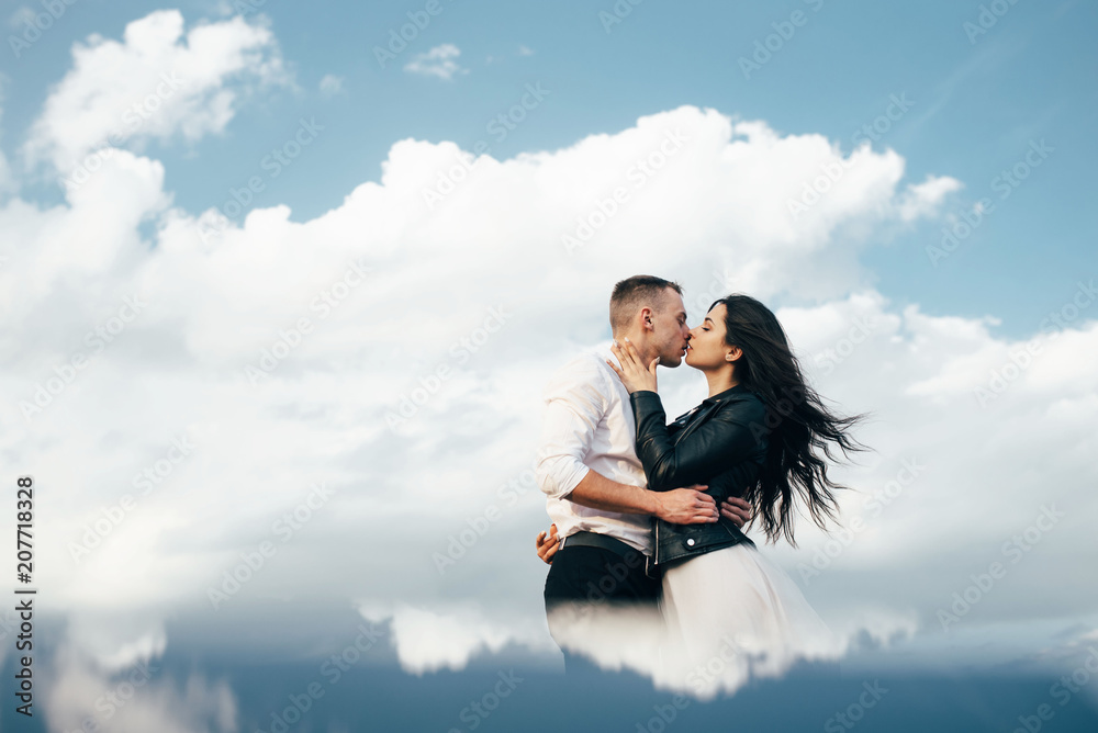 Beautiful romantic couple in love standing over blue sky.