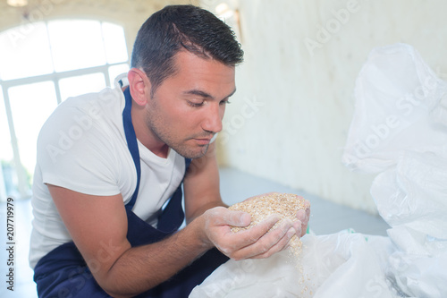 Male worker holding handful of grains photo