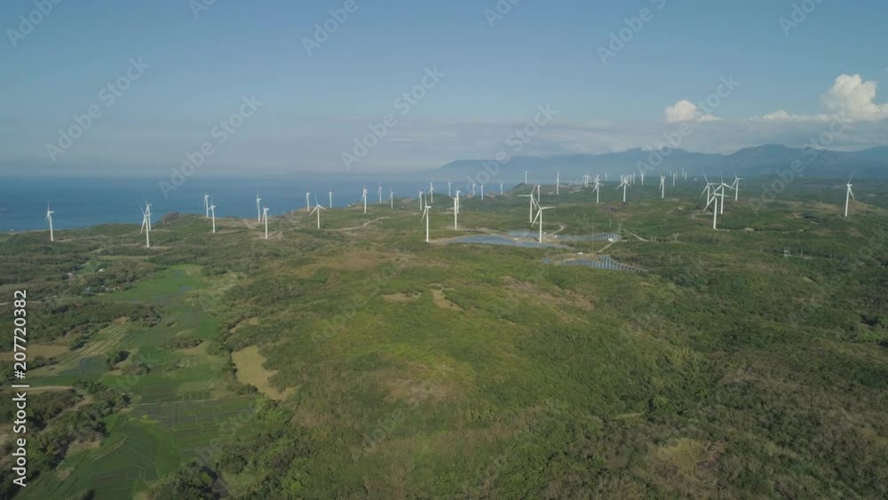 Aerial view of Windmills for electric power production on the seashore. Bangui Windmills in Ilocos Norte, Philippines. Solar farm, Solar power station. Ecological landscape: Windmills, sea, mountains. Aerial view of Windmills for electric power production on the seashore. Bangui Windmills in Ilocos Norte, Philippines. Solar farm, Solar power station. Ecological landscape: Windmills, sea, mountains.